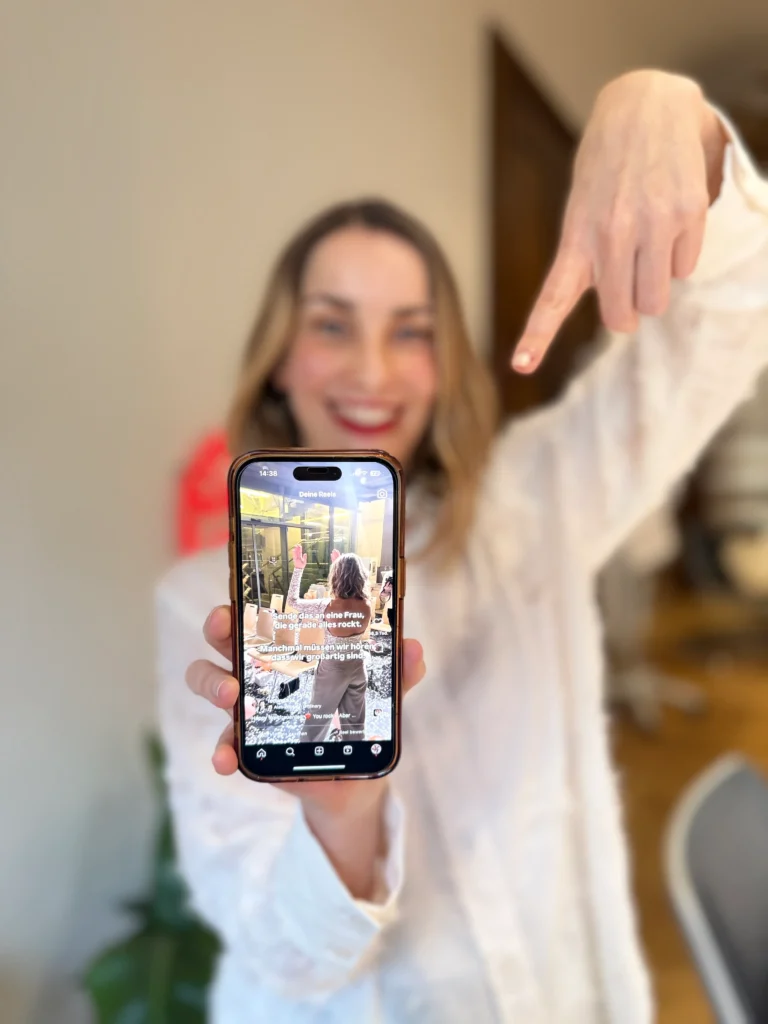 FEMINDS Gründerin hält Handy in Kamera und zeigt virales Reel